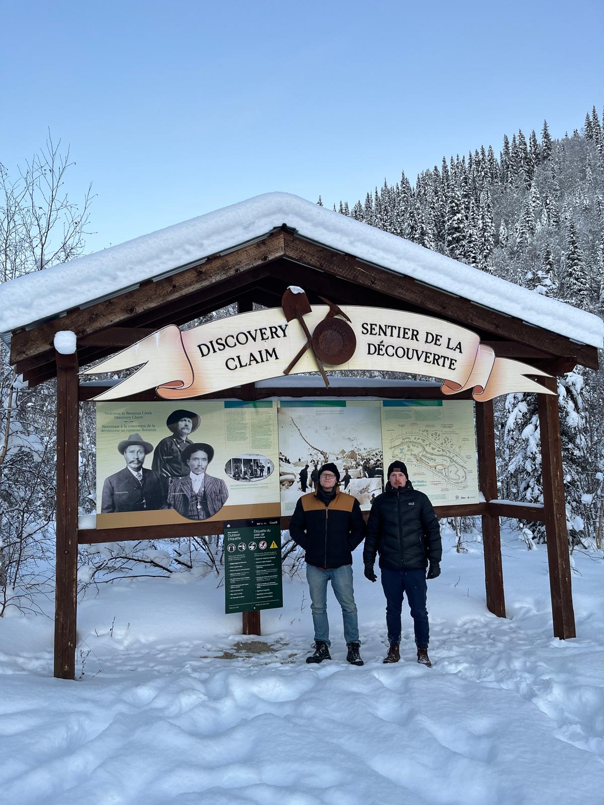 two men standing in front of Dawson Discovery sign