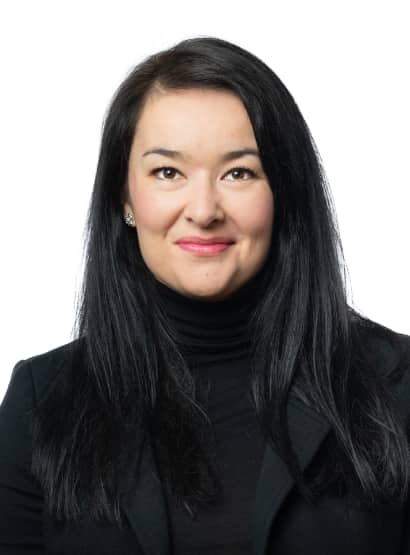 Portrait of a woman with black hair wearing a black turtleneck shirt and black blazer