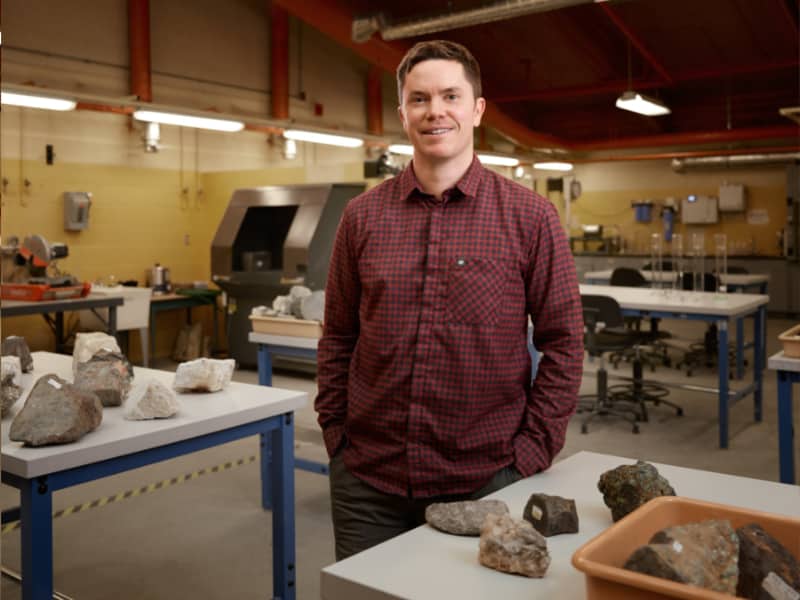 Joel Cubley posing in a geology lab