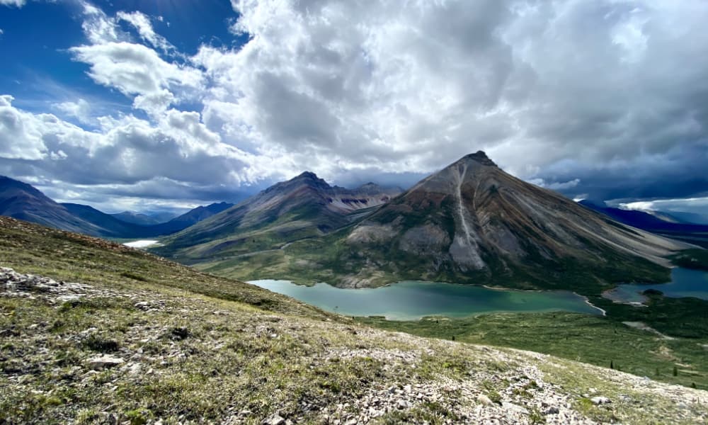 A wide angle view of a mountain range with lakes in the foreground