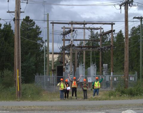 YukonU Northern Energy Innovation students and staff stand in front of a electrical sub-station