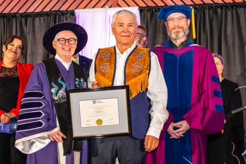 Stanley Njootli receiving a framed degree parchment from Dr. Lesley Brown and Dr. Ernie Prokopchuk