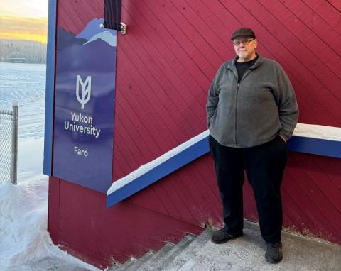 man standing in front of YukonU Faro campus sign