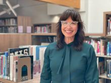 Portrait of Wendy Sokolon posing in front of shelves of library books